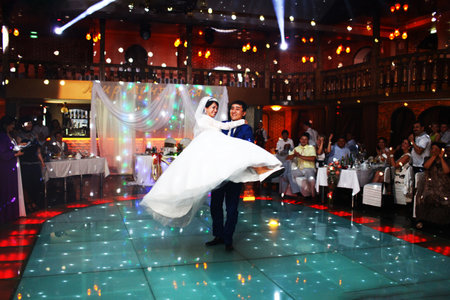 BAKU, AZERBAIJAN - JUNE 28, 2013: Happy bride and groom and their first dance, wedding in an elegant restaurant with wonderful lighting and atmosphere.のeditorial素材