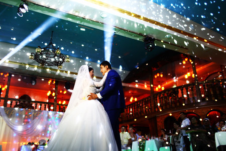 BAKU, AZERBAIJAN - JUNE 28, 2013: Happy bride and groom and their first dance, wedding in an elegant restaurant with wonderful lighting and atmosphere.のeditorial素材