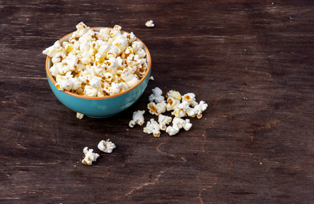 A plate of popcorn on a brown table, top viewの写真素材