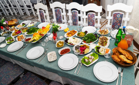 A festive and beautifully decorated wedding table. Decorated with flowers.various bottles of drinks, beautiful dishes, salads and sliced meat rolls.vegetable slicing.の写真素材