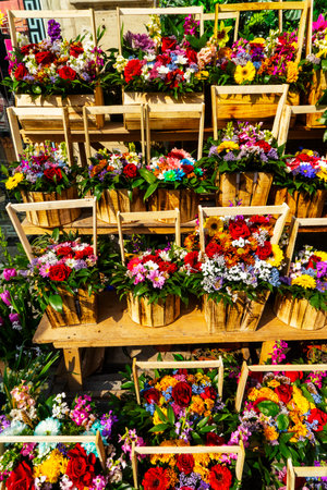 The concept of a flower shop. Fresh spring flowers of different varieties in wooden baskets . Bouquets on the shelf, floral business.の写真素材