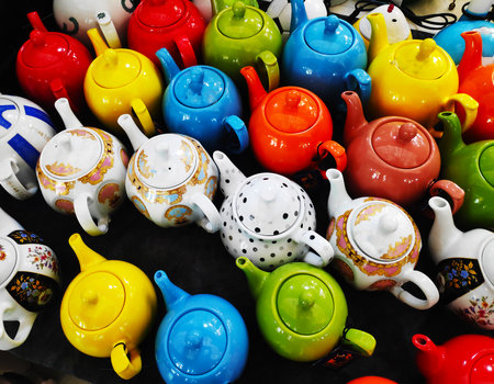 Beautiful multicolored oriental-style teapots are on sale at the market. An oriental ceramics street shop. Sale of traditional ceramic tableware during the festival.の写真素材