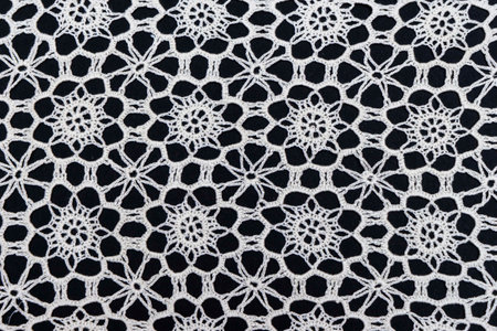 Vintage handmade white knitted napkin isolated on a black backgroundの写真素材