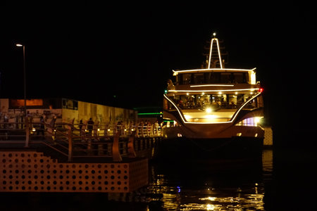 A pleasure ship with burning lights is moored on the seashoreの写真素材