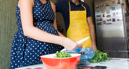 woman in kitchen preparing a fresh vegetable saladの写真素材