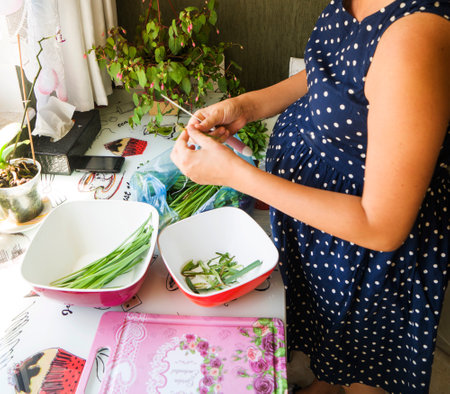 woman in kitchen preparing a fresh vegetable saladの写真素材