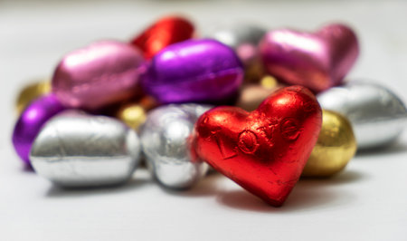 Multicolored heart shaped chocolates on a white background. close up. St. Valentine's Day Concept.の写真素材