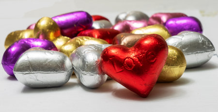 Multicolored heart shaped chocolates on a white background. close up. St. Valentine's Day Concept.の写真素材