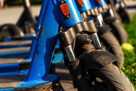 Rented blue electric scooters parked in the parking lot are ready for use - this is a very familiar...