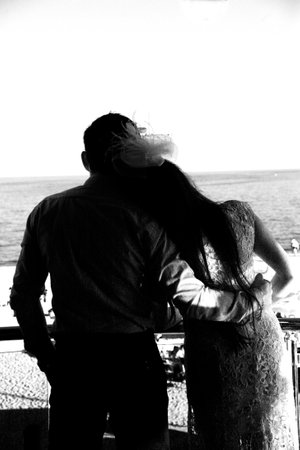 groom carries his bride in his arms through the old townの写真素材