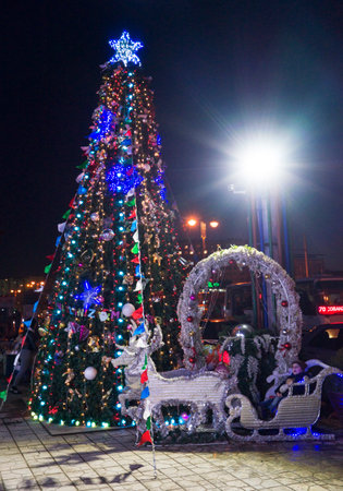 Close up of Christmas tree with ornaments of baubles, snowflakes, teddy bears, sleighs, gingerbread house, pine cones and lights.の写真素材