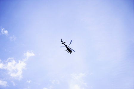 helicopter flying in the blue cloudy skyの写真素材
