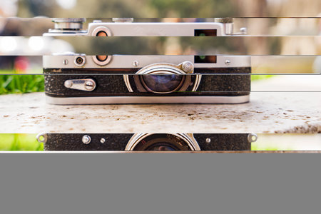 Vintage digital camera on boulder over blurred nature background. Shallow depth of field with focus on camera. Outdoor. Retro picture style.の写真素材