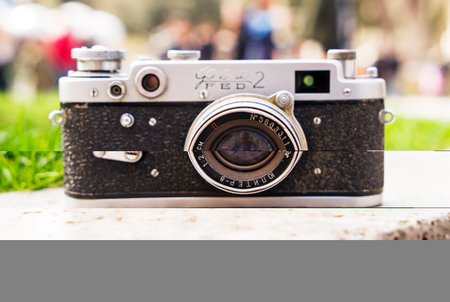 Vintage digital camera on boulder over blurred nature background. Shallow depth of field with focus on camera. Outdoor. Retro picture style.の写真素材