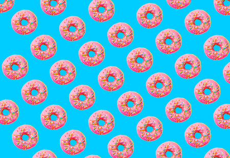 Pink glazed donut pattern on blue pastel background. Creative conceptの写真素材