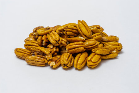 Pile Pecan nuts isolated on white background. Heap shelled Pecans nut closeup. Tasty raw organic food and healthy snackの写真素材
