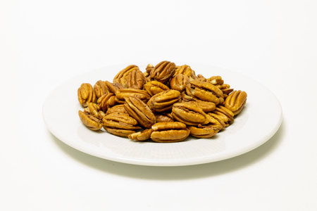 Pile Pecan nuts isolated on white background. Heap shelled Pecans nut closeup. Tasty raw organic food and healthy snackの写真素材