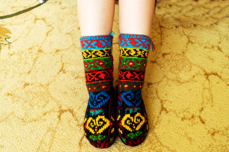 Beautiful wool socks made of multicolored threads on the girls feetの写真素材