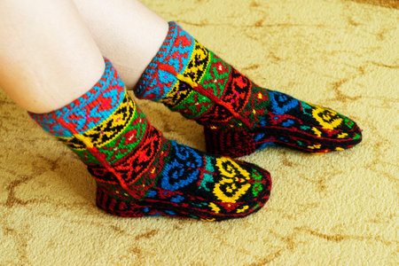 Beautiful wool socks made of multicolored threads on the girls feetの写真素材