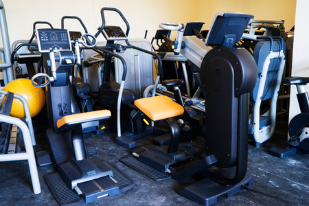 Modern gym interior with equipment. Fitness club with row of treadmills for fitness cardio training in evening backlight.の写真素材