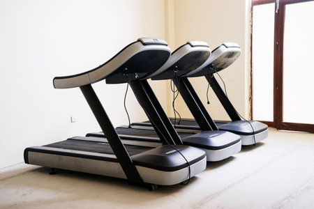 Modern gym interior with equipment. Fitness club with row of treadmills for fitness cardio training in evening backlight. Healthy lifestyle conceptの写真素材