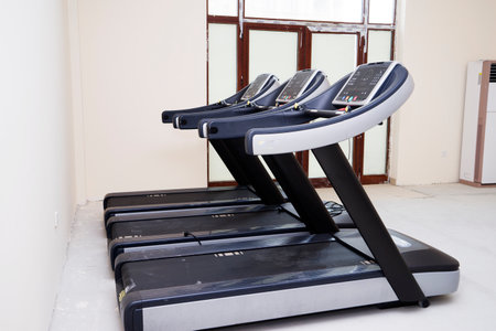 Modern gym interior with equipment. Fitness club with row of treadmills for fitness cardio training in evening backlight. Healthy lifestyle conceptの写真素材