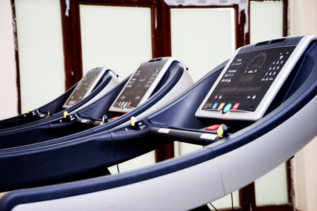 Modern gym interior with equipment. Fitness club with row of treadmills for fitness cardio training in evening backlight. Healthy lifestyle conceptの写真素材