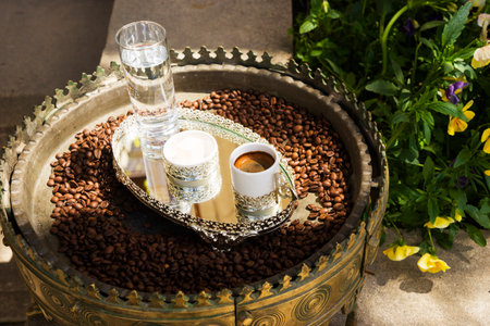 coffee in a white Cup, water, coffee beans on a tray is in the yardの写真素材