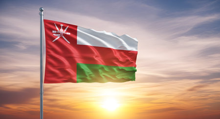 The Omani flag is prominently displayed waving in the breeze, set against a striking sunset backdrop.の素材