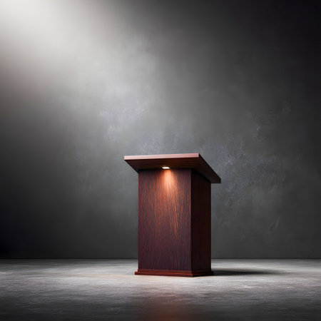 A brown wooden podium is dramatically lit in a studio setting with textured background and spotlight.の素材
