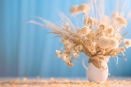 Bouquet of dried flowers on white table against beige backgroundの素材