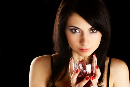 Portrait of a beatifull woman with a glass of wine. Black background. Studio shot.の写真素材