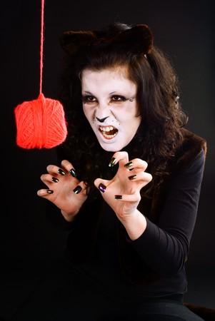 Cat-girl playing with a threads ball. Studio shot.の写真素材