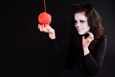 Cat-girl playing with threads ball. Studio shot.の写真素材