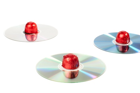 Set of sweets placed on CDs. Isolated on white background.
