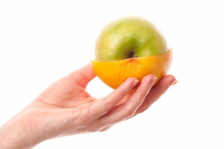 female hand holdin half of an apple and half of a grapefruit. White background. Studio shotの写真素材