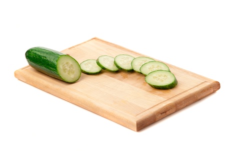 sliced cucumbers on the carving board. White background. studio shot.の写真素材