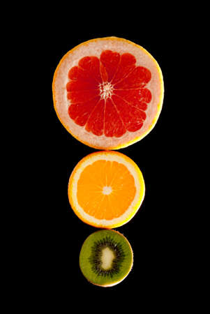 Traffic lights made of kiwi, orange and grapefruit on black background. Studio shot.の写真素材