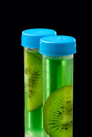 Lb tubes filed with liquid of with fruits parts on black background.