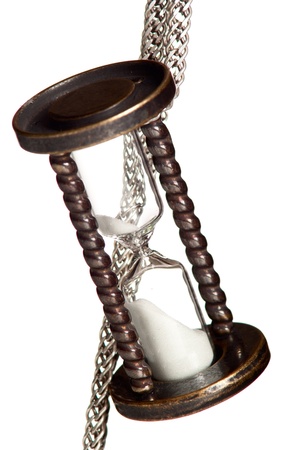 Hourlass with silver chain on black background. Studio shot.