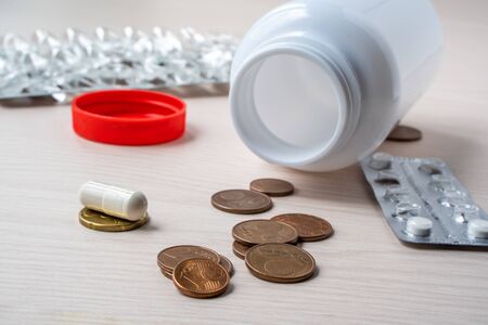 Empty blister packs and medicine bottle with coins. Money spent on drugs. Concept of expensive drugs...