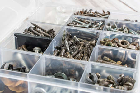 Screws, bolts, nuts and other carpenter stuff in a plastic toolbox (hardware organizer). Stock photo.の写真素材