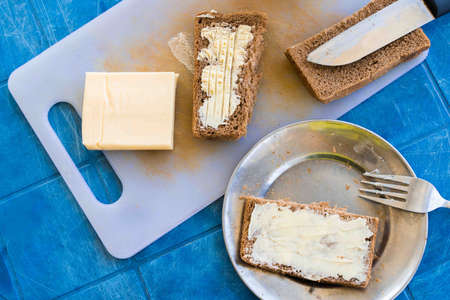 Bread with butter, set for a short breakfast. Simple rustic vegetarian food concept. Flat lay top...