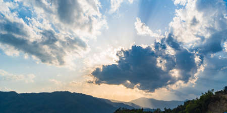 Bright Sunlight Comes Through Hole of Clouds to a Dark Scene of a Mountain Range During Sunset Time....