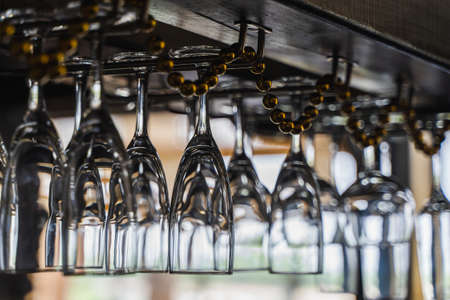 Wine glasses hanging over the bar. Soft focusの写真素材