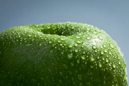 Green apple covered in water dropletsの写真素材