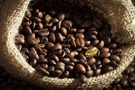 Golden coffee seed on burlap coffee sackの写真素材