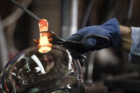 Glassmaker in factory creates bowl glassの写真素材