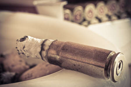 Bullets abd cigars in the ashtrayの写真素材
