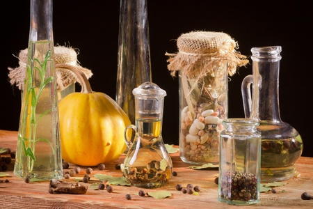 Spices and bottle of oil on wooden plankの写真素材